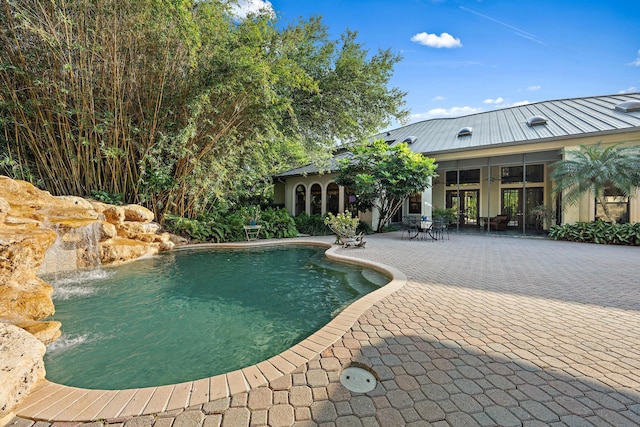 outdoor pool featuring a patio area and french doors