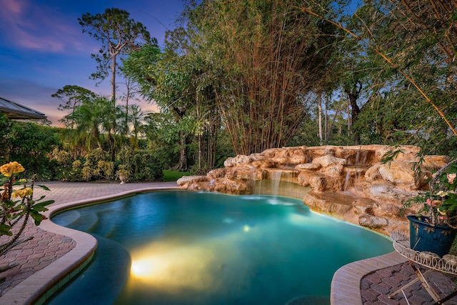 pool at dusk with an outdoor pool