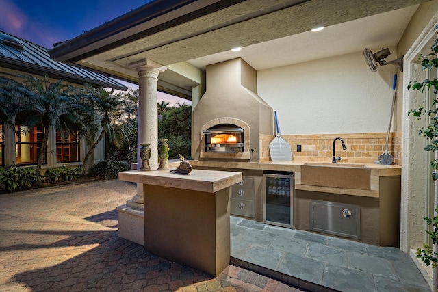 view of patio / terrace with an outdoor kitchen, wine cooler, and a sink