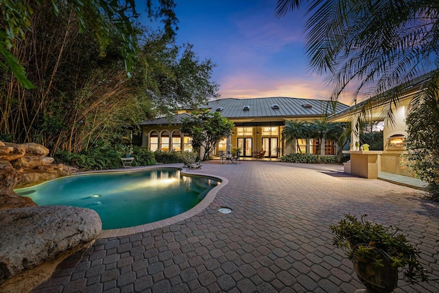 outdoor pool with french doors and a patio area