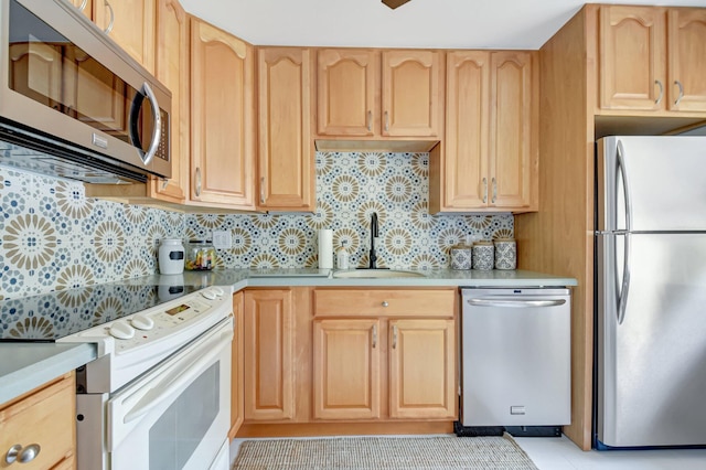 kitchen with light countertops, a sink, stainless steel appliances, and light brown cabinetry