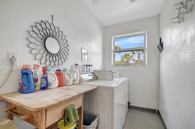 washroom featuring baseboards, separate washer and dryer, and laundry area