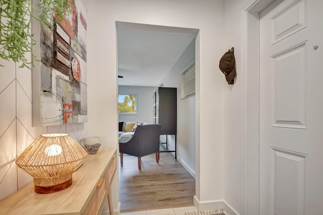 corridor featuring baseboards and light wood-style floors