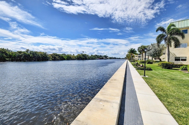 exterior space featuring a lawn and a water view
