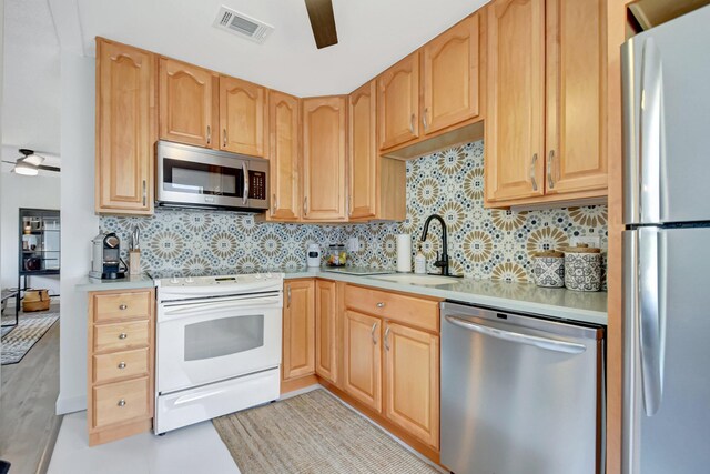 kitchen featuring light countertops, visible vents, stainless steel appliances, a ceiling fan, and a sink