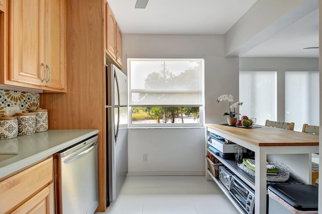 kitchen with baseboards, stainless steel appliances, and tasteful backsplash