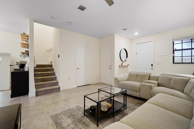 living area featuring light tile patterned floors, baseboards, stairway, and visible vents