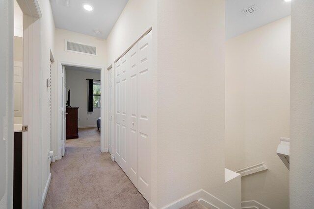 corridor with baseboards, carpet flooring, and visible vents