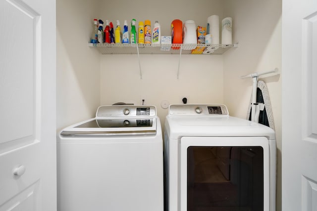 clothes washing area with washer and clothes dryer and laundry area