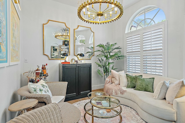 living area featuring a chandelier, wood finished floors, and baseboards