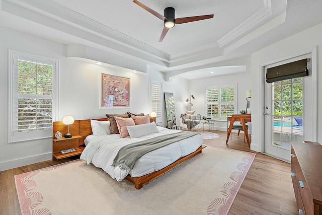 15415 Alexander Run, Jupiter, FL 33478 - bedroom with ornamental molding, a raised ceiling, access to exterior, light wood-type flooring, and a ceiling fan