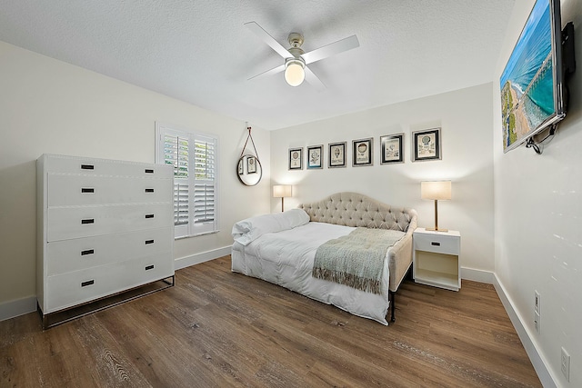 bedroom featuring wood finished floors, baseboards, a textured ceiling, and a ceiling fan