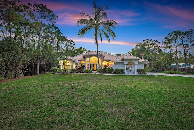 15415 Alexander Run, Jupiter, FL 33478 - mediterranean / spanish house featuring stucco siding, a front lawn, concrete driveway, and french doors