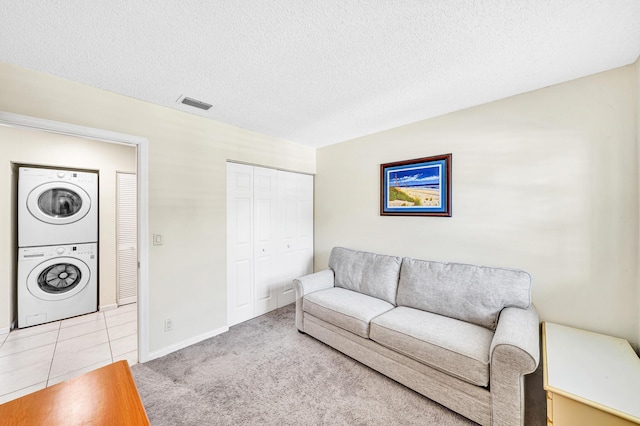 3050 Norwood Pl Unit N208, Boca Raton, FL 33431 - living room featuring stacked washer / dryer, a textured ceiling, visible vents, and carpet floors