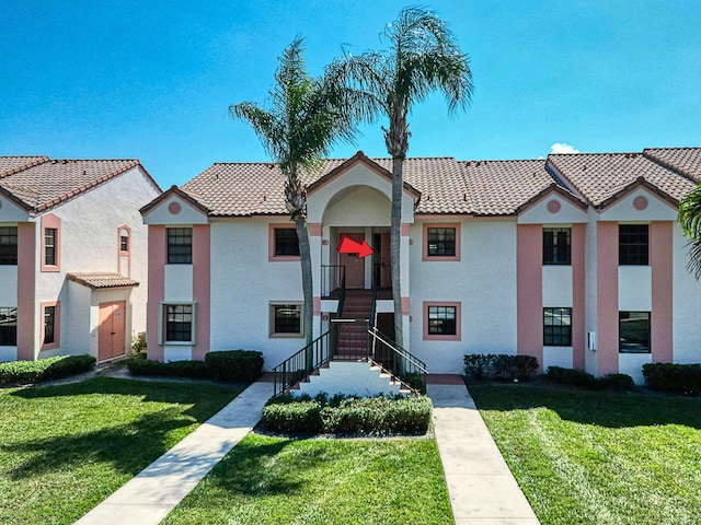 3050 Norwood Pl Unit N208, Boca Raton, FL 33431 - view of front facade with a tile roof, stucco siding, and a front lawn