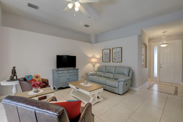 living room with baseboards, visible vents, light tile patterned floors, and a ceiling fan