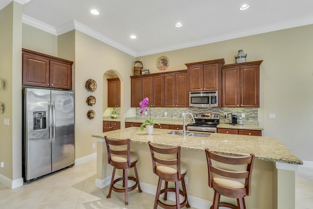 16988 SW Ambrose Way, Port Saint Lucie, FL 34986 - kitchen with a kitchen breakfast bar, arched walkways, tasteful backsplash, a sink, and appliances with stainless steel finishes
