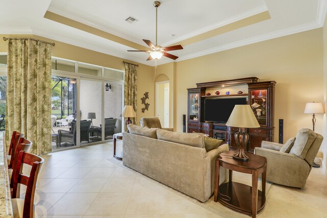 16988 SW Ambrose Way, Port Saint Lucie, FL 34986 - living area with crown molding, a raised ceiling, arched walkways, light tile patterned floors, and visible vents