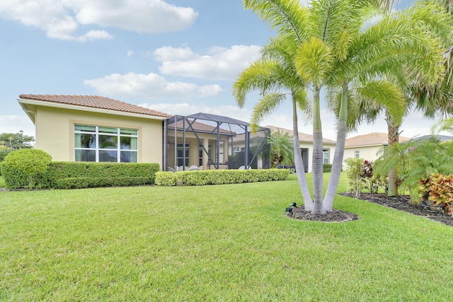 16988 SW Ambrose Way, Port Saint Lucie, FL 34986 - back of house featuring a yard, a tile roof, glass enclosure, and stucco siding
