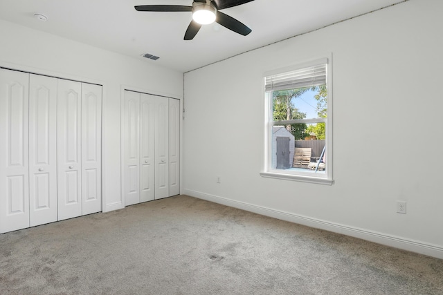 1041 SW Dartmouth Ave, Port Saint Lucie, FL 34953 - unfurnished bedroom with visible vents, baseboards, two closets, a ceiling fan, and carpet floors