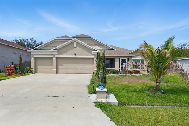 1041 SW Dartmouth Ave, Port Saint Lucie, FL 34953 - view of front of property with stucco siding, roof with shingles, a front lawn, an attached garage, and driveway