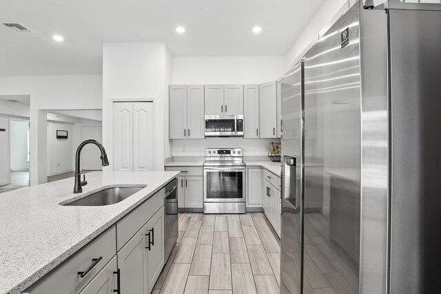 1041 SW Dartmouth Ave, Port Saint Lucie, FL 34953 - kitchen featuring visible vents, recessed lighting, appliances with stainless steel finishes, light stone counters, and a sink