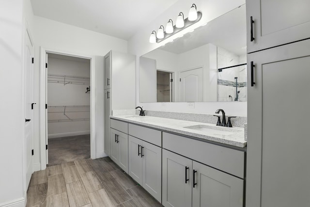 1041 SW Dartmouth Ave, Port Saint Lucie, FL 34953 - full bathroom featuring a stall shower, double vanity, a sink, and a walk in closet