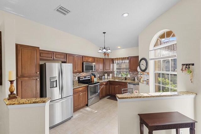 kitchen with a peninsula, a sink, tasteful backsplash, visible vents, and appliances with stainless steel finishes