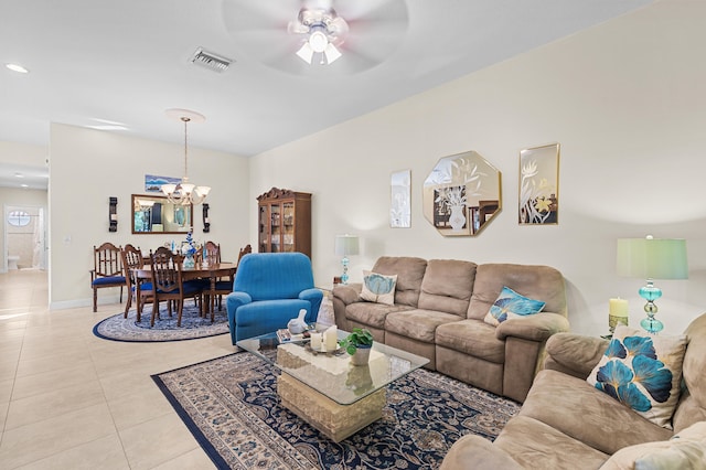 living room with baseboards, light tile patterned flooring, visible vents, and ceiling fan with notable chandelier