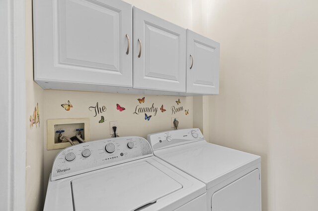 washroom featuring separate washer and dryer and cabinet space