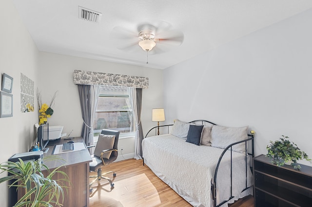 bedroom with baseboards, wood finished floors, visible vents, and ceiling fan