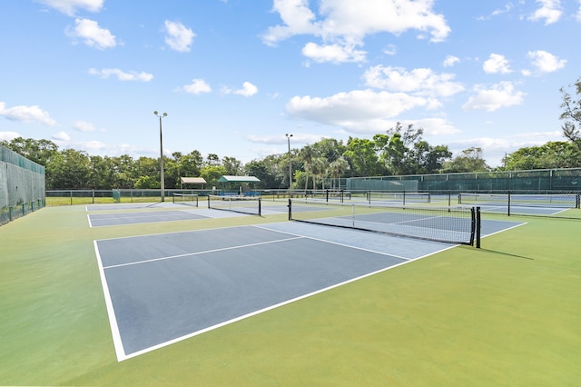 view of tennis court featuring community basketball court and fence
