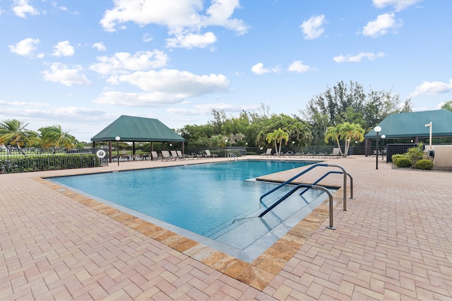 pool with fence, a gazebo, and a patio