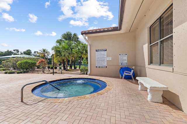 view of swimming pool featuring a hot tub