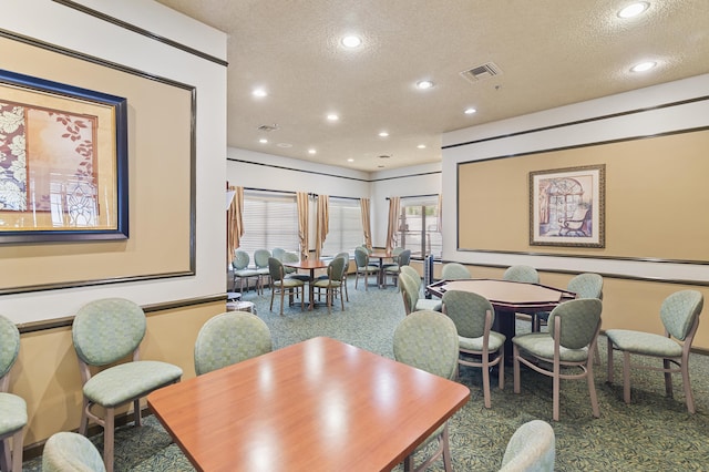 carpeted dining area featuring visible vents, a textured ceiling, and recessed lighting