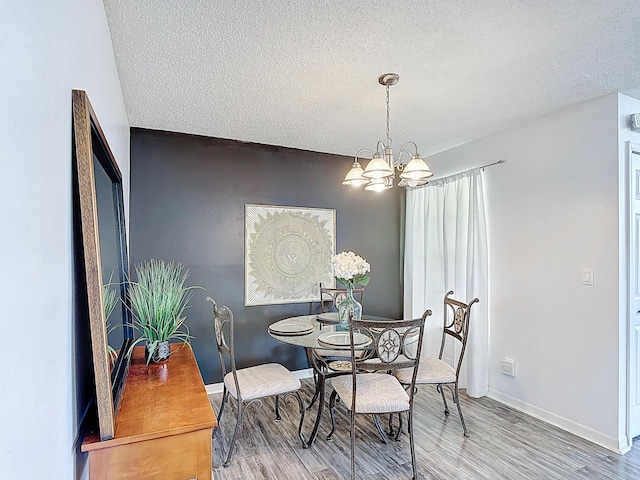 5005 Laguna Bay Cir Unit 26, Kissimmee, FL 34746 - dining space with baseboards, light wood-type flooring, a notable chandelier, and a textured ceiling