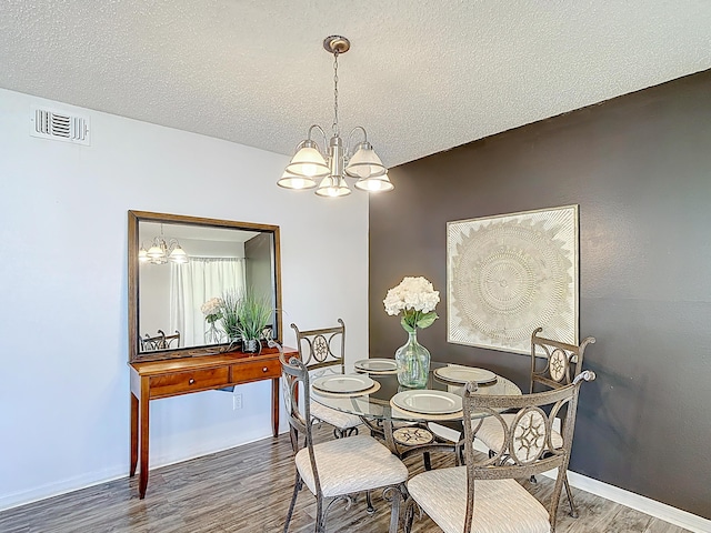 5005 Laguna Bay Cir Unit 26, Kissimmee, FL 34746 - dining room with an inviting chandelier, wood finished floors, visible vents, and a textured ceiling