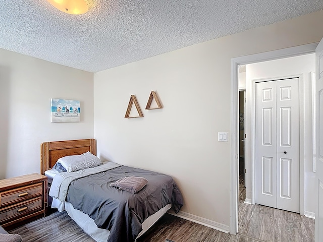 5005 Laguna Bay Cir Unit 26, Kissimmee, FL 34746 - bedroom featuring baseboards, wood finished floors, and a textured ceiling