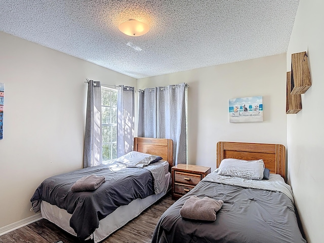 5005 Laguna Bay Cir Unit 26, Kissimmee, FL 34746 - bedroom featuring a textured ceiling, wood finished floors, and baseboards