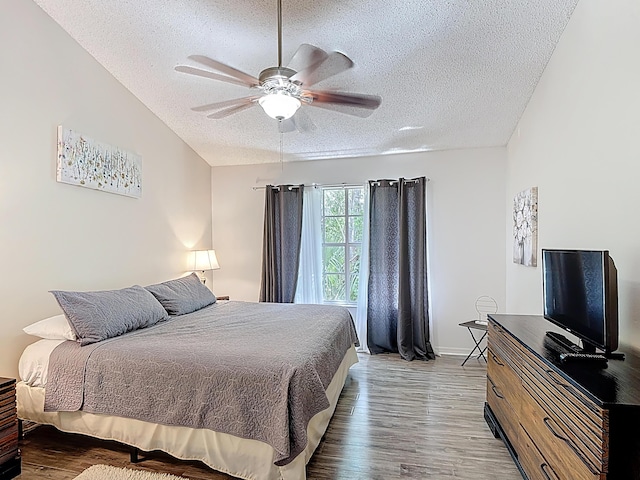 5005 Laguna Bay Cir Unit 26, Kissimmee, FL 34746 - bedroom featuring wood finished floors, a ceiling fan, a textured ceiling, and vaulted ceiling