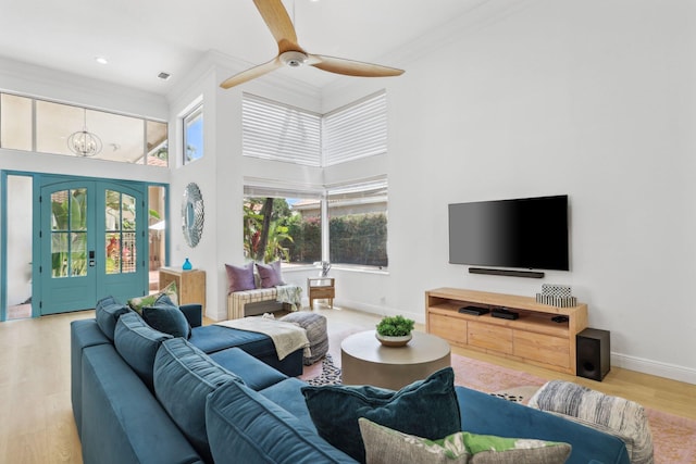 living area featuring french doors, ornamental molding, baseboards, and wood finished floors