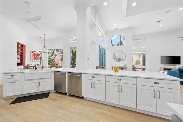 kitchen featuring light countertops, light wood-type flooring, ceiling fan with notable chandelier, and open floor plan