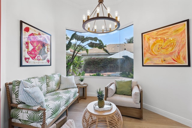 sitting room featuring baseboards, wood finished floors, and a chandelier