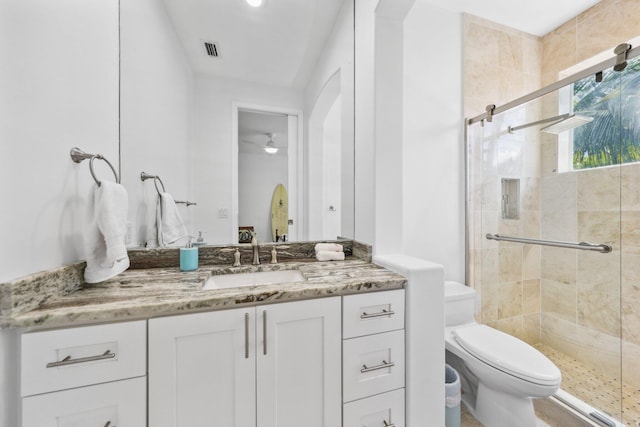 full bathroom with a stall shower, toilet, vanity, a ceiling fan, and visible vents