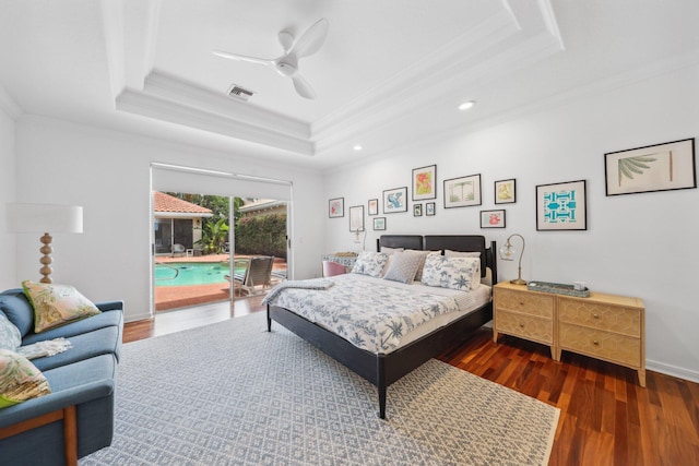 bedroom featuring a tray ceiling, wood finished floors, access to outside, visible vents, and ornamental molding