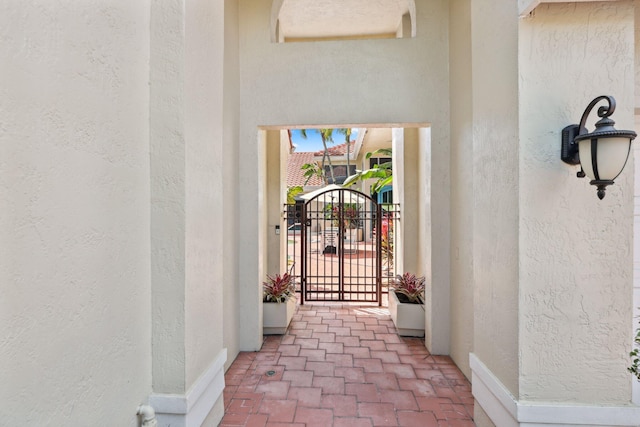 doorway to property featuring a gate and stucco siding