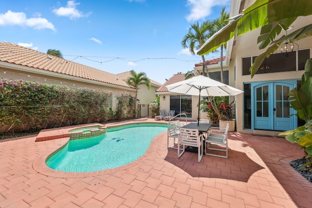 view of pool with a patio, french doors, and a pool with connected hot tub