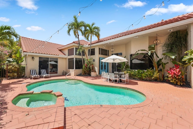 view of swimming pool featuring fence, a pool with connected hot tub, and a patio area