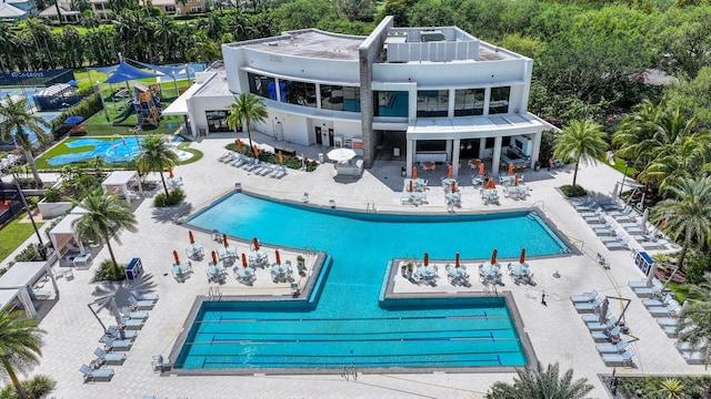 back of property with fence, a community pool, and a patio