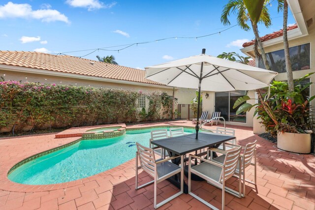 view of pool with a pool with connected hot tub, outdoor dining area, and a patio